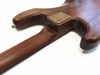 Close-up of the smooth wooden neck joint and back body of a handcrafted electric guitar with a metal neck plate and strap button on a white background.