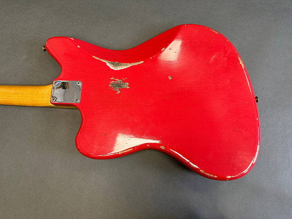 Red electric guitar body with worn and chipped paint finish, maple neck heel and chrome neck plate on gray background