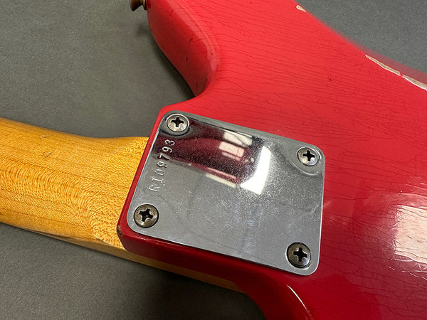 Close-up of vintage red electric guitar neck plate with serial number R109793 and natural wood neck at Coffee House Guitars.