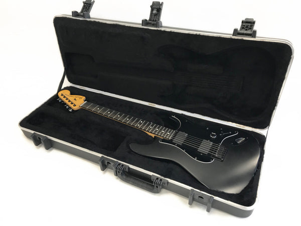 Black Fender electric guitar with maple neck and rosewood fretboard in hard shell case with black plush interior