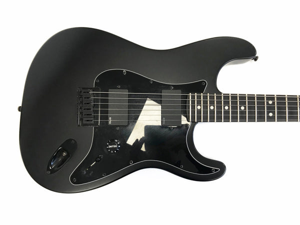 Matte black electric guitar body with dual EMG pickups, black pickguard, volume knob, and six strings on white background