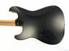 Black electric guitar body back with bolt-on maple neck and string ferrules, shown on white background
