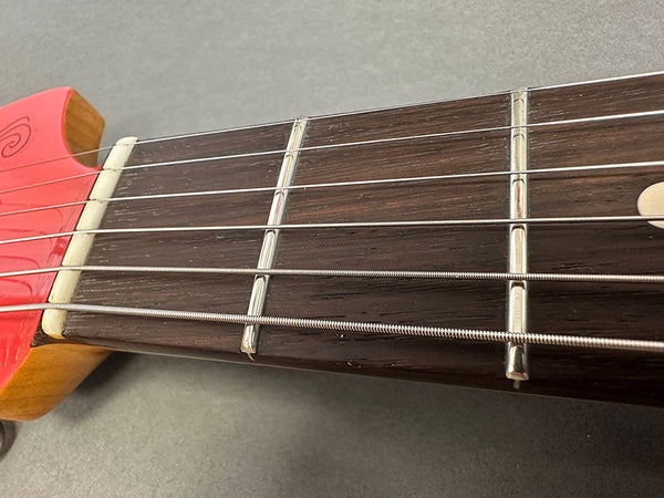 Close-up of acoustic guitar fretboard and metal strings near the guitar nut by Coffee House Guitars