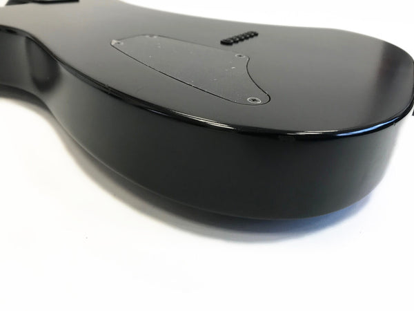 Close-up of black electric guitar body back with control cavity cover and glossy finish on white background