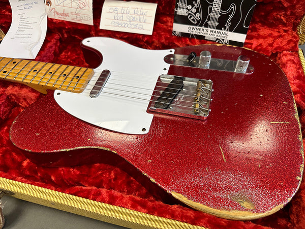 Fender 1958 Telecaster Relic Red Sparkle electric guitar with worn finish, maple neck, white pickguard, and vintage style bridge, displayed in red plush-lined guitar case with owner's manual and paperwork.