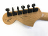 Back of natural wood guitar headstock with black tuning pegs, serial number US11278632, made in USA, and a signature on the left side.