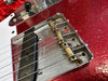Close-up of vintage Fender Telecaster bridge and pickup on red sparkle guitar body with six strings and black control knob