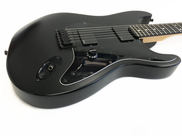 Black electric guitar with dual EMG pickups, volume knob, and black pickguard on white background