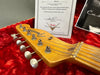 Fender Custom Shop guitar headstock with tuning pegs and certificate of authenticity on red plush case lining