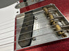Close-up of the bridge and pickup on a red sparkle Fender electric guitar showing vintage metal parts and strings