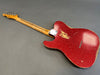 Vintage style red sparkle finish electric guitar body with visible wear and maple neck on gray background