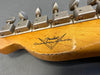 Close-up of vintage Fender Custom Shop guitar headstock with worn tuning pegs and aged wood finish