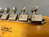 Close-up of vintage Fender Custom Shop electric guitar tuning pegs on wooden headstock with visible wear and original screws