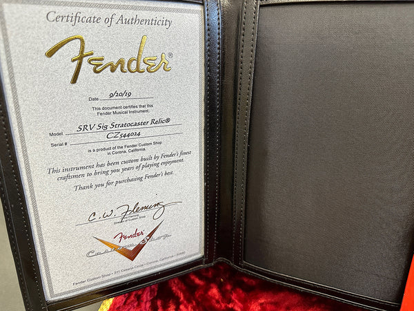 Fender Certificate of Authenticity for SRV Sig Stratocaster Relic guitar dated 9/20/19 with serial number CZ544024 in black leather certificate holder with red velvet guitar case lining