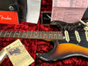 Fender vintage sunburst Stratocaster electric guitar with rosewood fretboard in red velvet case, showing checklist, Fender owner's manual, tremolo springs and inspection documents