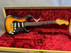 Fender Stratocaster SRV signature electric guitar in sunburst finish with black pickguard and white pickups, displayed in red plush-lined tweed hard case