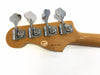 Back of Fender bass guitar headstock with chrome tuning pegs and serial number N6147659 on light wood finish