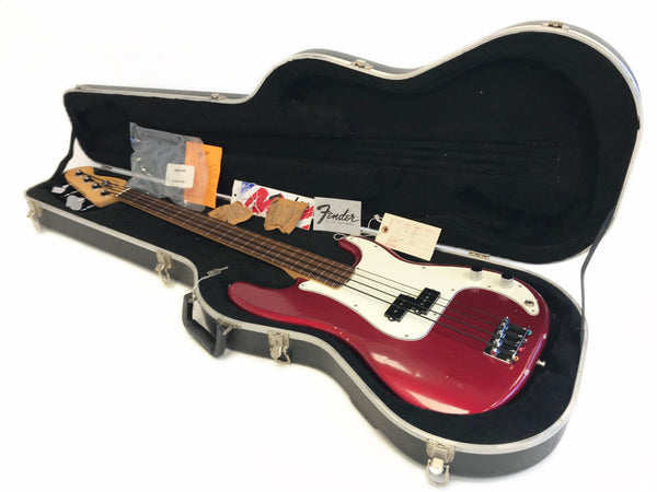 Fender electric bass guitar in red finish with white pickguard in black hard case with original tags and paperwork from Coffee House Guitars