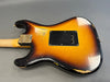 Vintage sunburst Fender electric guitar body with visible wear and scratches, back view showing neck joint and tremolo cavity cover plate on gray background