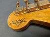 Close-up of Fender Custom Shop guitar headstock with vintage gold tuning pegs and worn natural wood finish