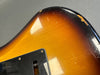 Close-up of sunburst electric guitar body showing wear and vintage finish near black pickguard at Coffee House Guitars
