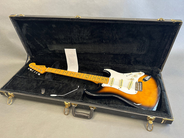 Fender Stratocaster electric guitar in sunburst finish inside black hard case with black plush interior, including tremolo arm and inspection sheet