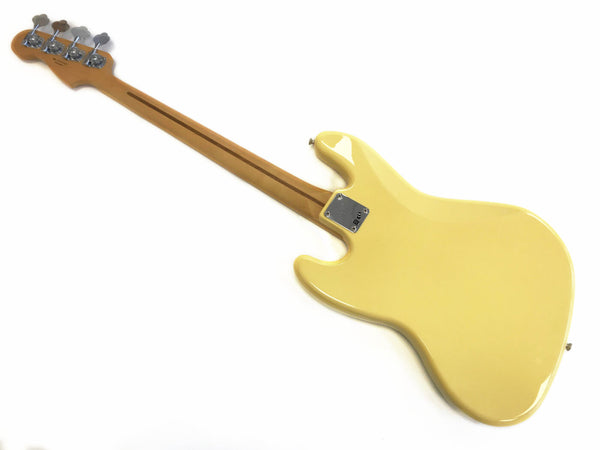 Vintage cream electric bass guitar back view with maple neck and chrome tuning pegs isolated on white background