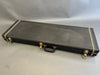 Black rectangular hard guitar case with metal latches and a handle on gray background