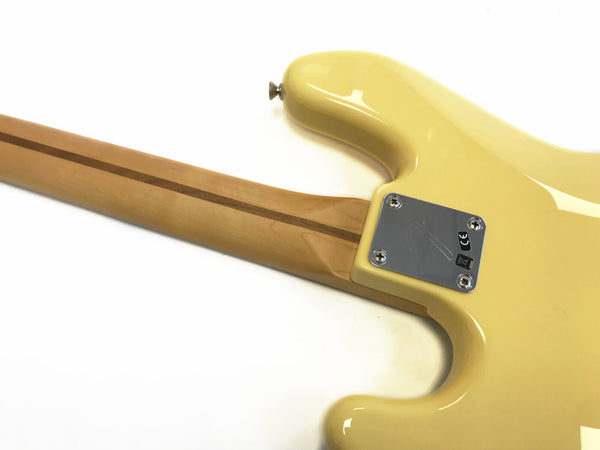 Yellow electric guitar back body and natural wood neck with skunk stripe and metal neck plate close-up on white background