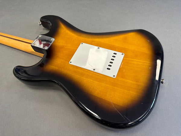 Vintage sunburst electric guitar back with maple neck and chrome neck plate on gray background