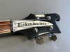 Close-up of vintage Rickenbacker Model 4010 bass guitar black headstock with tuning pegs and silver logo plate