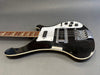 Black electric bass guitar with white pickguard and chrome hardware on gray background
