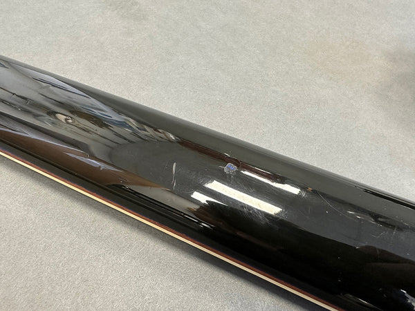 Close-up of black guitar neck back showing scratches and minor dents on glossy finish