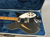 Black semi-hollowbody electric guitar with white pickguard, maple neck, and chrome hardware in blue plush-lined silver hard case