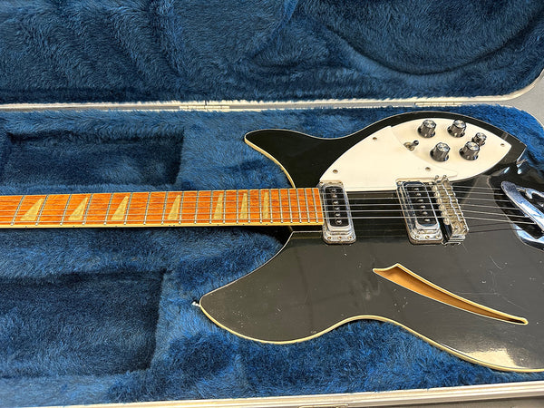Vintage black semi-hollow electric guitar with maple neck and triangle inlays inside blue plush-lined hard case