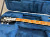 Rickenbacker guitar neck and headstock with triangular inlays resting in a blue plush guitar case