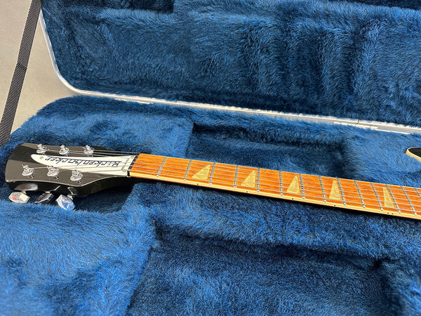 Rickenbacker guitar neck and headstock with triangular inlays resting in a blue plush guitar case