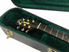 Guild acoustic guitar headstock with gold tuning pegs inside green plush lined black guitar case