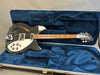 Black Rickenbacker electric guitar with white pickguard and maple fretboard in blue plush-lined hard case