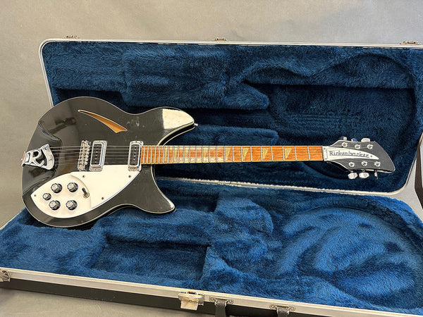Black Rickenbacker electric guitar with white pickguard and maple fretboard in blue plush-lined hard case