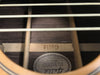 Close-up view of the interior bracing and label of a Guild acoustic guitar showing model and serial number details through the sound hole