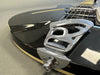 Close-up of black electric guitar body with chrome tailpiece and strings, showcasing guitar hardware and aged finish on Coffee House Guitars product listing.
