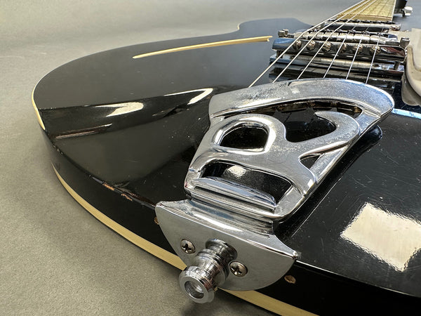 Close-up of black electric guitar body with chrome tailpiece and strings, showcasing guitar hardware and aged finish on Coffee House Guitars product listing.