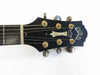 Guild acoustic guitar headstock with gold tuning pegs and mother-of-pearl inlay on black background