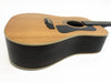 Acoustic guitar with natural wood top and dark wood sides displayed on white background from angled side view