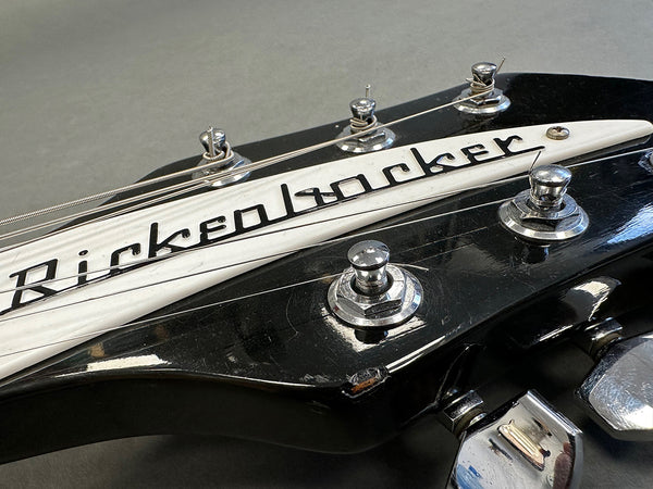Close-up of black Rickenbacker guitar headstock with tuning pegs and strings at Coffee House Guitars product listing