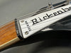 Close-up of Rickenbacker electric guitar headstock with "Made in U.S.A." label and steel strings, showing wood neck and black body finish.