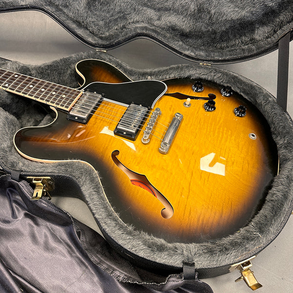 Semi-hollow electric guitar with sunburst finish and dual humbucker pickups in a plush-lined hard shell case