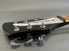 Close-up of black vintage Rickenbacker guitar headstock with six chrome tuning pegs and white truss rod cover on grey background
