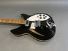 Black semi-hollow body electric guitar with white pickguard, chrome hardware, and maple neck on gray background